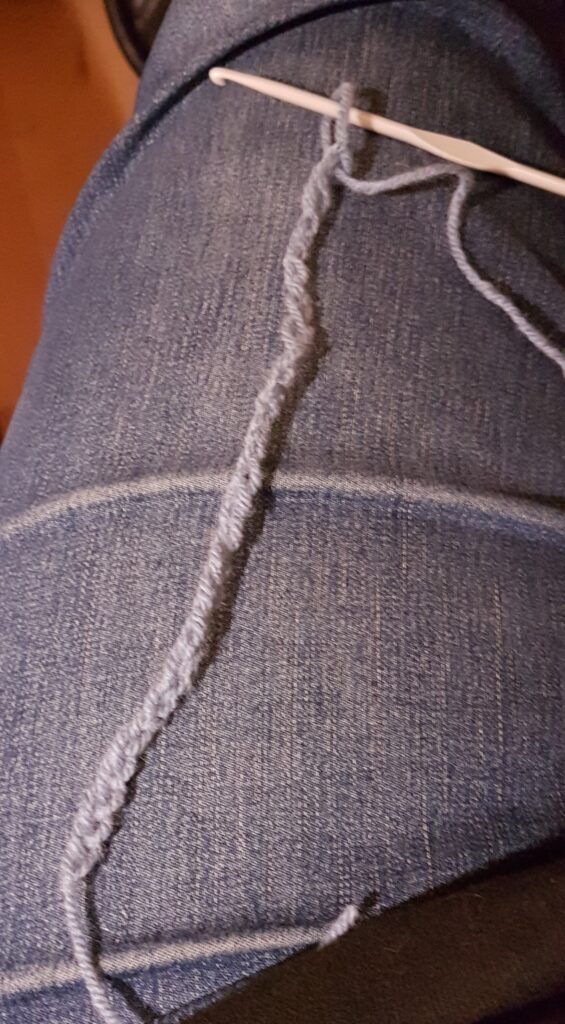Image shows a row of crocheted chain stitches in a baby blue wool.